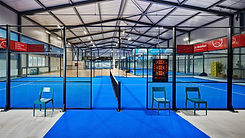 Innenansicht der Padel Arena Sursee mit mehreren blauen Indoor-Courts