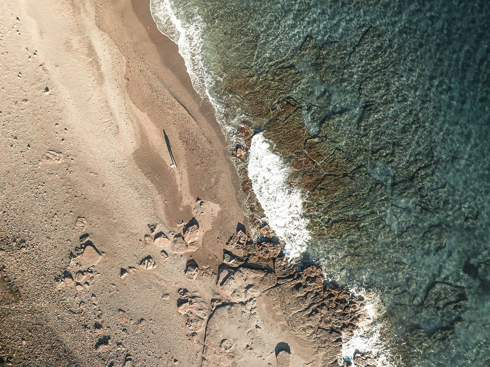 An individual strolling along the shoreline of a beach