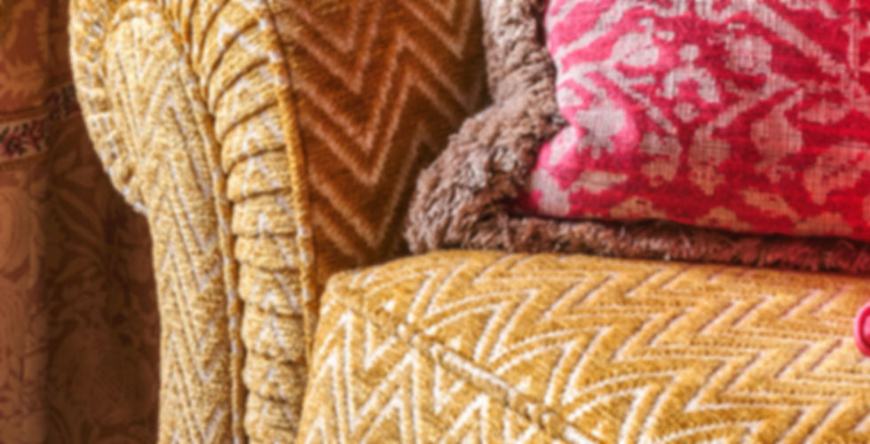 A close up of a sofa with pink cushions in my North London home that I designed the interior of myself