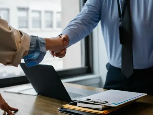 A man and woman shaking hands over the table.