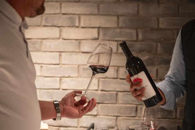 Rotwein wird in ein Glas eingeschenkt