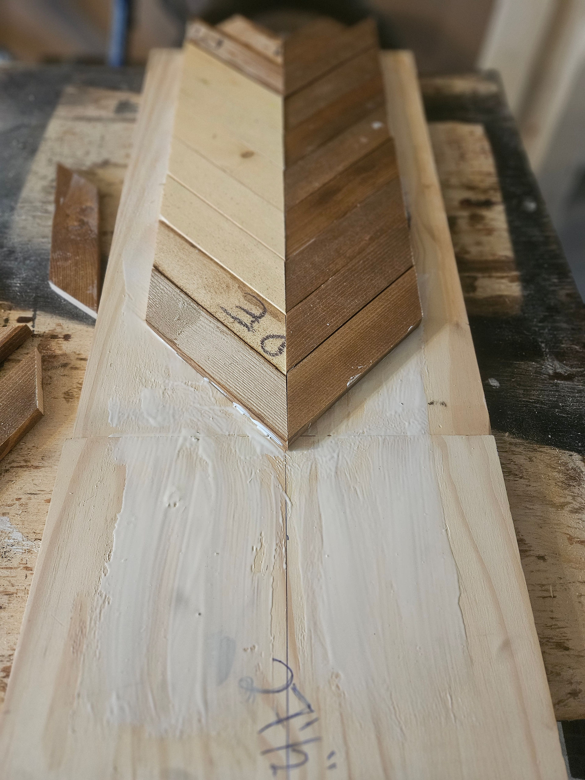 An image of half of the mitered wood pieces glued into chevron pattern