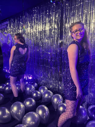 Lucy in the jumpsuit, stood in a "Guts" themed room