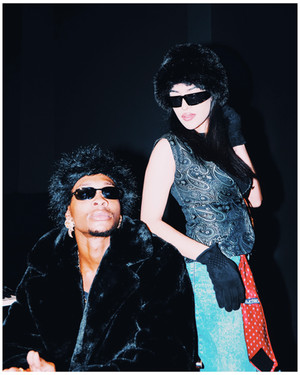 Two people wearing sunglasses and winter attire posing for the camera