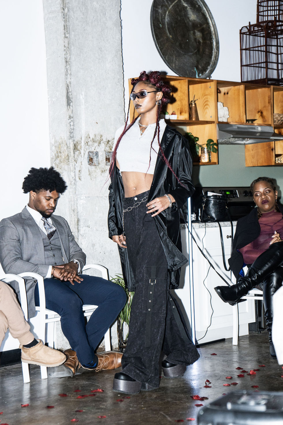 Fashion model in sunglasses poses, Metamorphosis- WNTR '25 Debut Show, with audience.