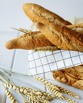 bread in basket with teatowel on white backround