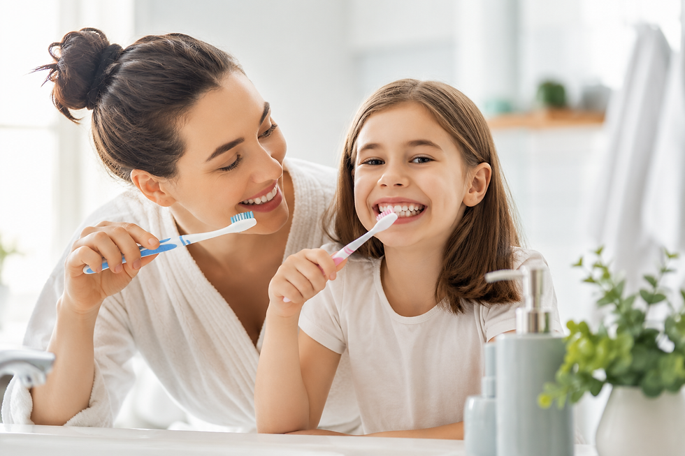 Mother and daughter brushing their teeth together in a bright bathroom to help keep their smiles healthy and naturally white.