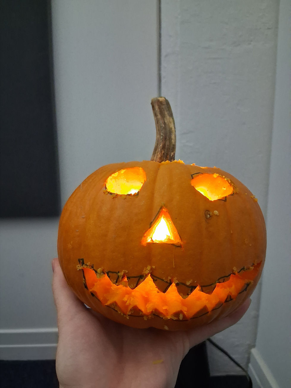 A carved jack-o'-lantern with glowing eyes and mouth.