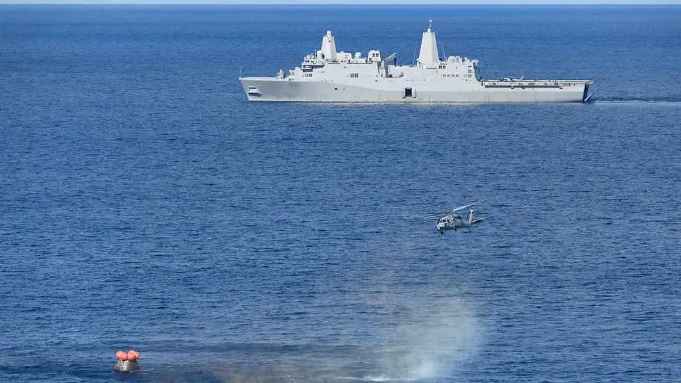 Naval ship and helicopter over blue sea, with spacecraft in the foreground.
