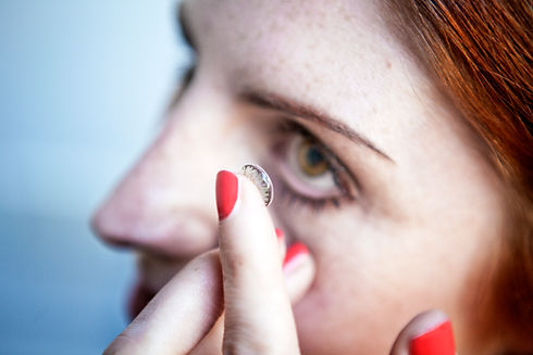 young woman putting contact in eye.jpg
