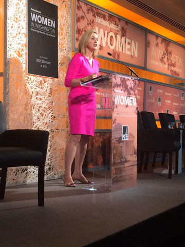 Photo of Laura Cox Kaplan speaking on a stage at a Women's event