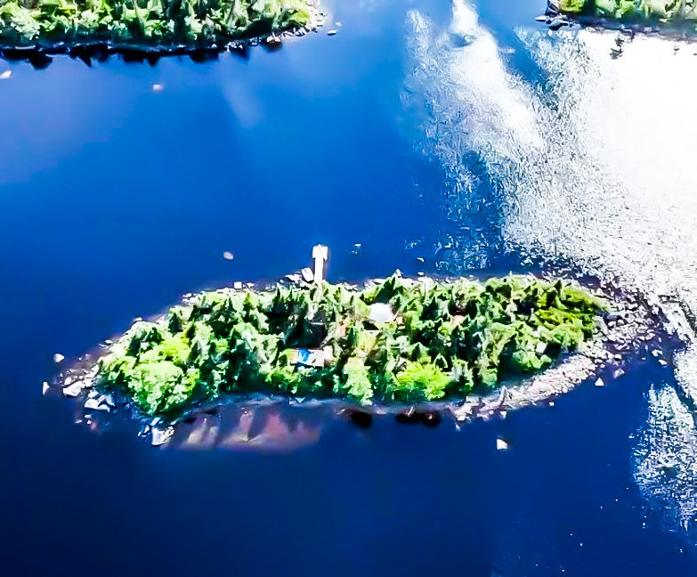 Ariel View of our Off Grid Island Nature Retreat project. Sunny day, forested island surrounded by water