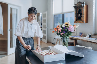 Kathy Bresler, founder of ALTAR is opening a box of cupcakes from food vendors
