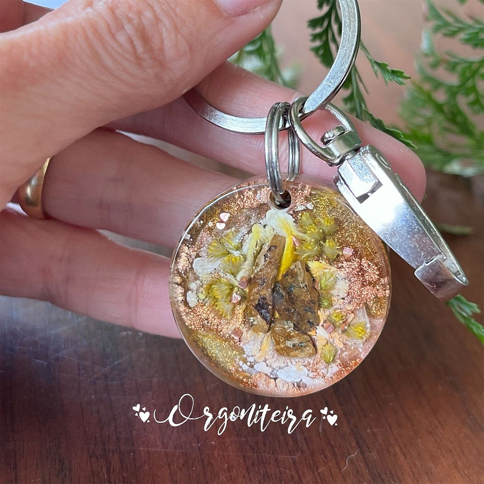 Chaveiro de orgonite feito de resina, metal e cristais de bronzita e quartzo