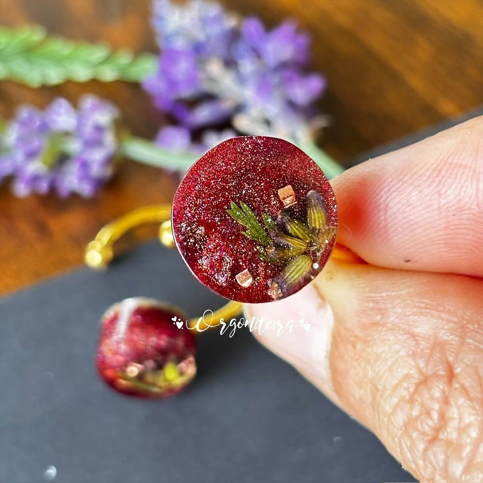 Anel dourado de orgonite com granada, selenita, quartzo e flores de lavanda francesa em tom vermelho translúcido.