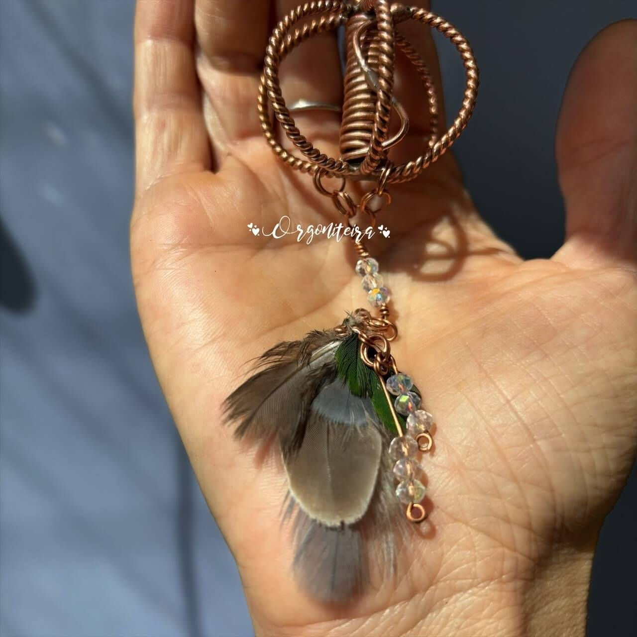 Mini Harmonizador Xamânico Tensorial em cobre com seis hastes torcidas e penas naturais de aves diversas.