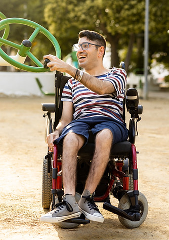 jongeman in een rolstoel speelt met een speeltuig