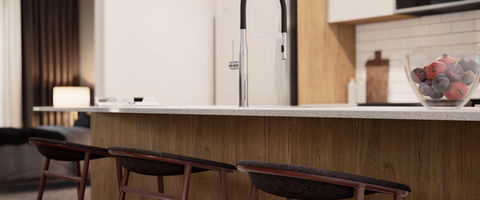 3D rendering of a kitchen with three stools and a bowl of fruit on the counter. 3D rendering design by Tangram Studio.