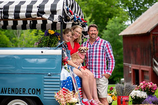 Owner's of Peacham Lavender Farm of Vermont, Cindy and Dan with their daughter and dog sitting in the bed of their blue 1962 VW truck, Ringo.