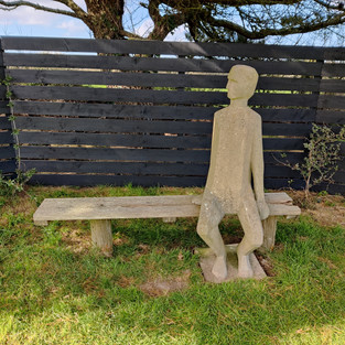 A statue of a lone figure on a bench