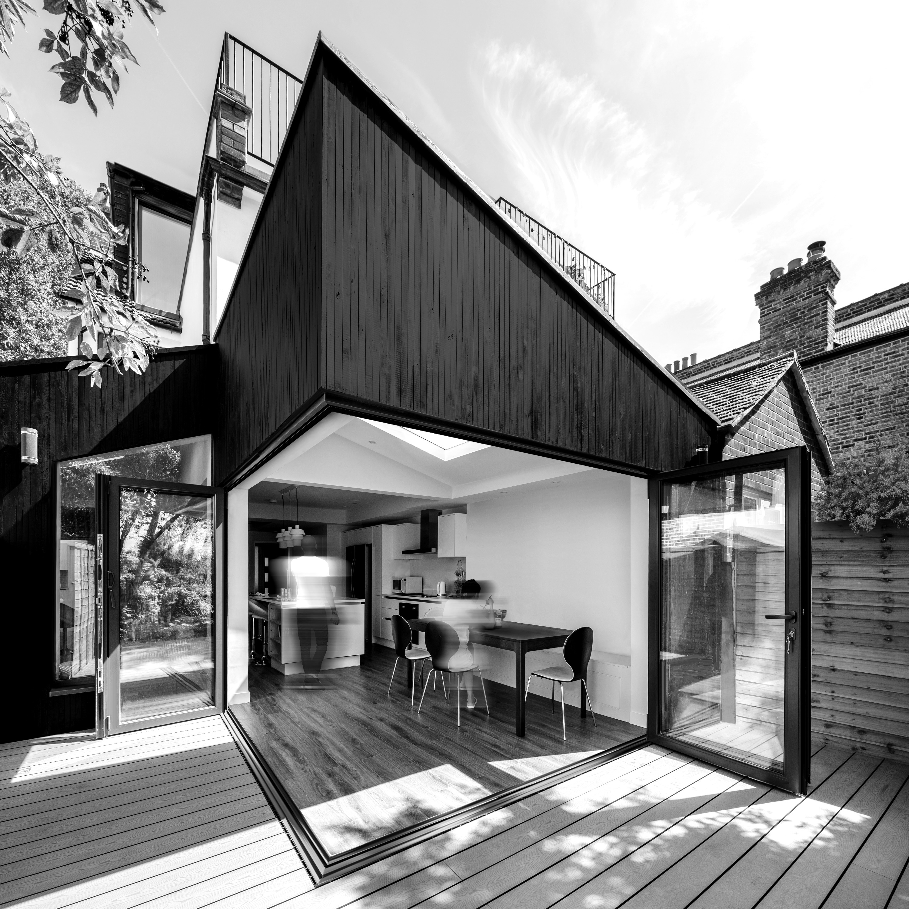 Mulhern Iremonger Design Studios — Rear and side extension to a 1950s semi-detached house in Wimbledon, featuring corner bifold doors, rooflights and open-plan living spaces.