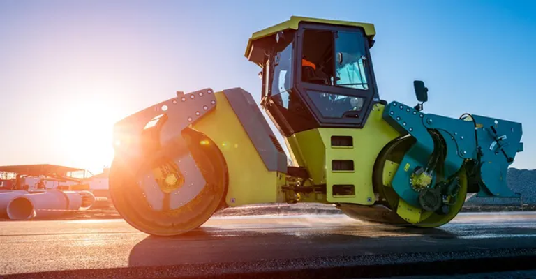 large tractor with sun shining behind it