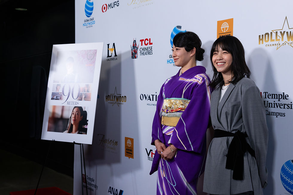Miho Kanno in a purple kimono and Nanase Nishino in a gray outfit beside the "90 Meters" poster on the Global Stage Hollywood 2026 red carpet at the TCL Chinese Theatre.