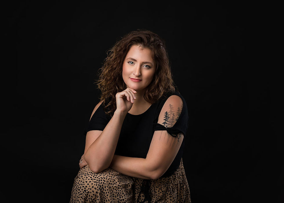 woman with tattoo on her shoulder and curly brown hair