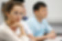 Close-up of students' faces watching a lecture.