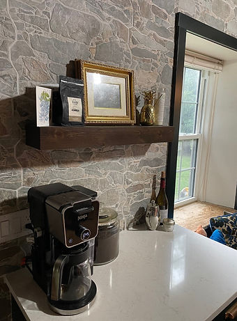 Custom Cabinetry Kitchen, dark green colour with white countertop coffee bar. Floating shelf is located above the coffee bar.