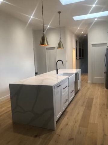 Custom Cabinetry - Kitchen, white custom island with sink and lighting overhead