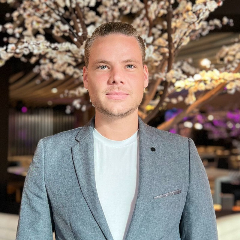 Artem Sholokhov linkeding porrait , blond blue eyes man in suit in restaurant