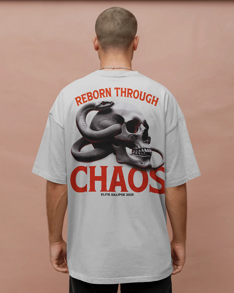 Peach background t shirt mockup back view of man in loose fit shirt posing with ‘Reborn Through Chaos’ skull and snake