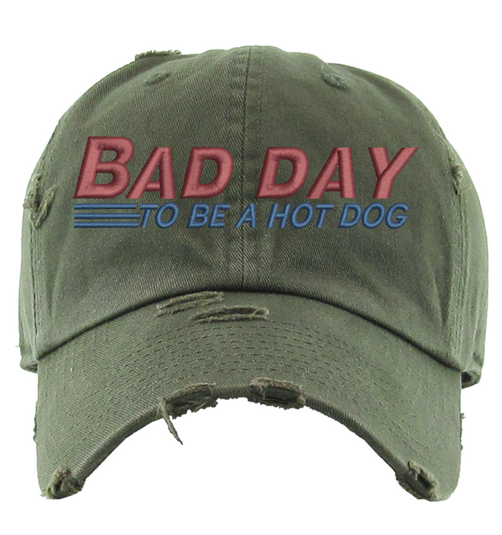 Green distressed dad hat with the embroidered text "Bad Day to Be a Hot Dog".