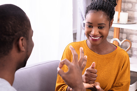Smiling Young Couple Sitting On Sofa Com