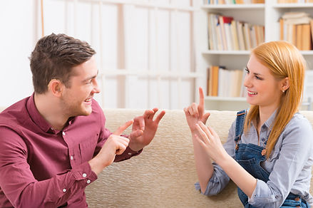 Smiling young woman talking using sign l