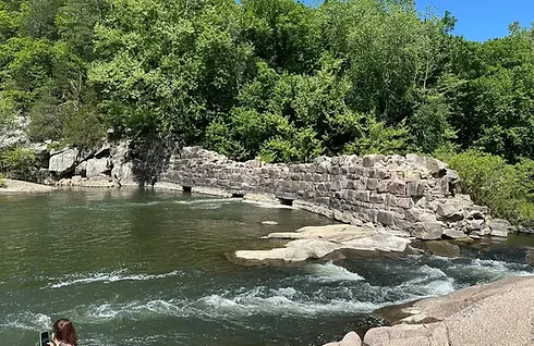 River with stone wall and green trees