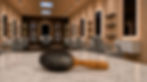 Bass Brushes Hairbrush on marble counter in an empty modern salon with lit mirrors and gray styling chairs; Genuine Bass on handle.