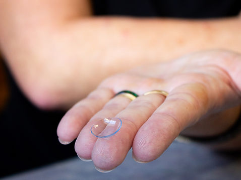 Close-up of a contact lens resting on a fingertip