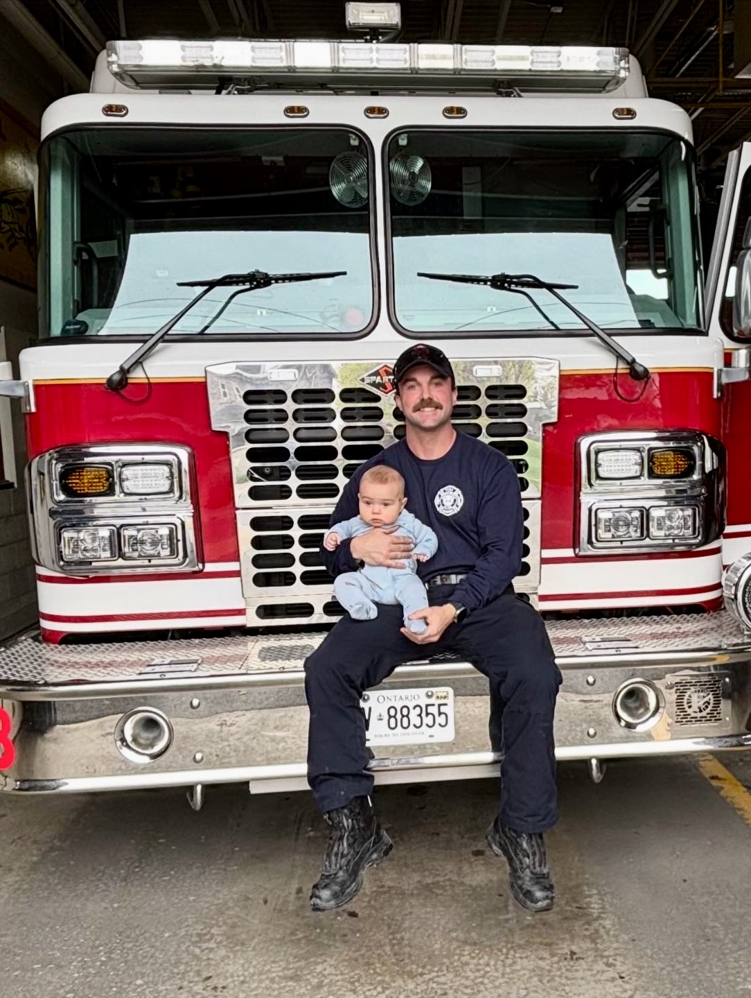 Eric Hurtubise with child in front of fire truck
