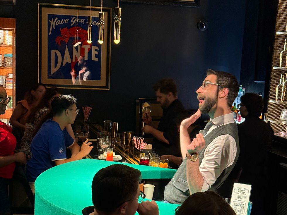 Man in vest animatedly talking at a bar with a glowing green counter. People seated, vibrant drinks, and "Have you seen DANTE" poster.