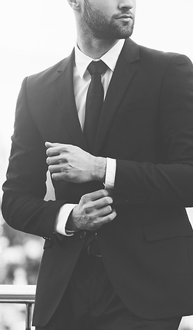 Modern businessman. Confident young man in full suit adjusting his sleeve and looking away