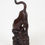 Thumbnail: A carving of a tiger in dark finely grained wood. The tiger with head down as it descends a rocky slope covered in bamboo.