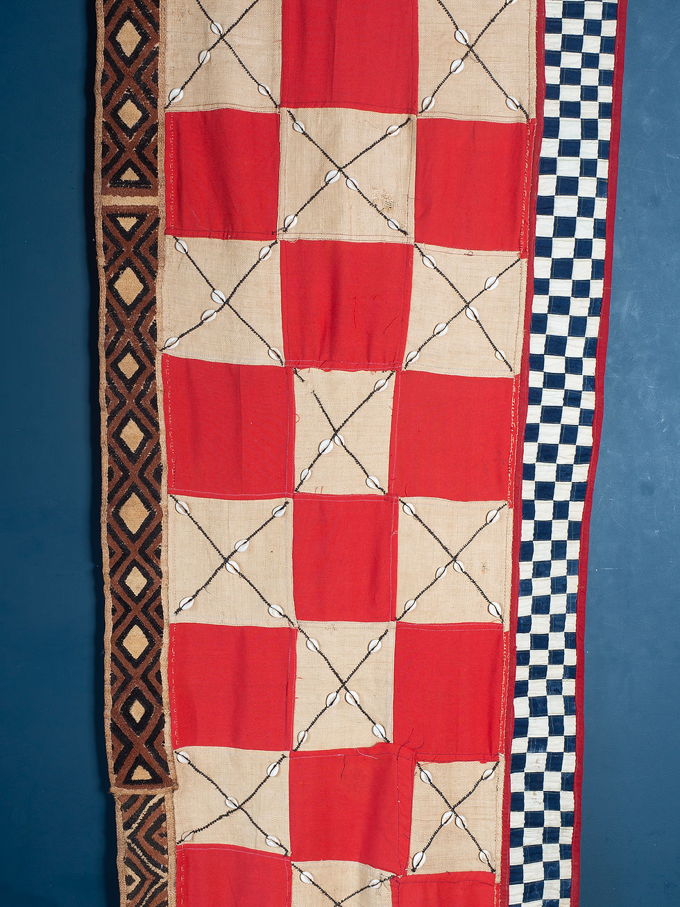 Thumbnail: A  tall wall hanging the central panel of red and white check panels. Bordered with woven raffia and blue and white check