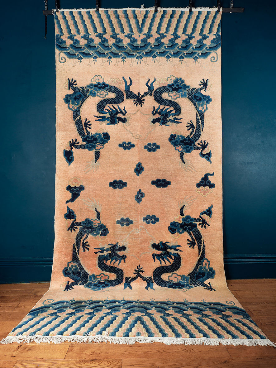A Chinese rug with 2 pairs of matched five clawed dragons among clouds on a peach coloured ground