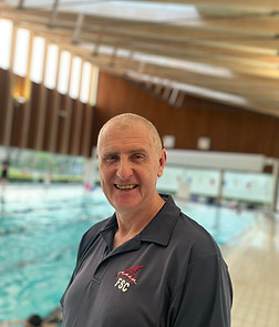 Coach Paul is smiling poolside and wearing the Formby Swimming Club polo shirt