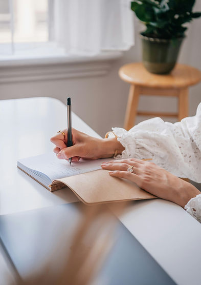Main qui écrit dans un cahier lors d'une séance de psychothérapie