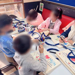 Children hand-painting canvas bags as gifts for their mums for Mother's Day - at Qs School, holistic education and tutoring centre in Melbourne.