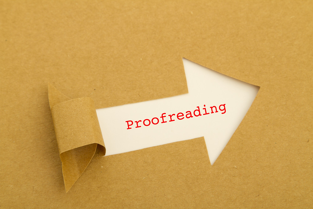 The word "proofreading" typed in red on white paper