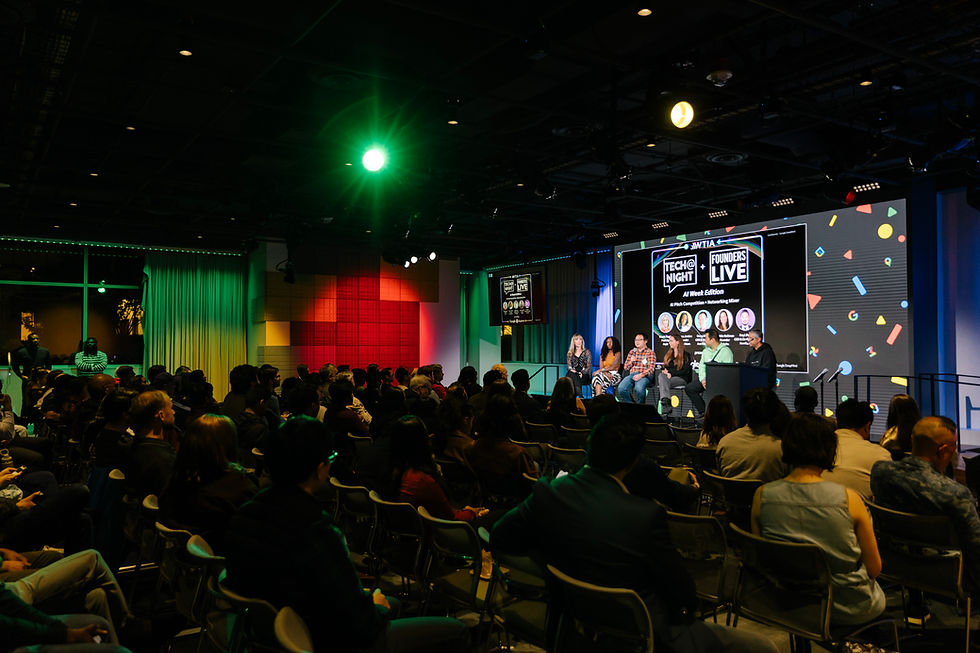 Presenters speaking on stage in front of large audience